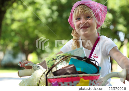 Nice little girl riding her bike on a road Nice little girl riding her bike on a road 23579026