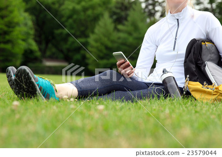 Fitness woman with mobile phone having a rest Fitness woman with mobile phone having a rest 23579044