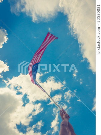 American flag with stars and stripes hold with hands against blue sky ( Filtered image processed vintage effect ) American flag with stars and stripes hold with hands against blue sky ( Filtered image processed vintage effect ) 23580881