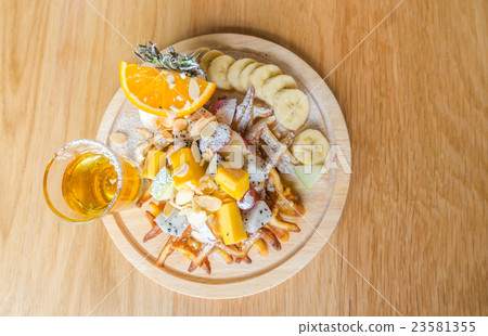 Waffle and fruit with ice cream on table . 23581355