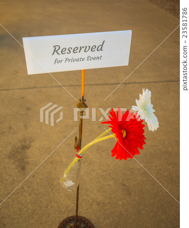Table with sign of "reserved" and flower . 23581786