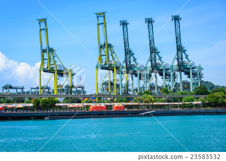 Cargo cranes in jetty by the water over blue sky Cargo cranes in jetty by the water over blue sky 23583532