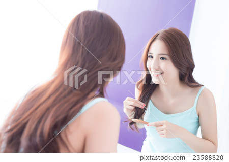 young woman is combing hair 23588820