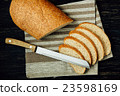 Sliced bread and knife on linen cloth, black table 23598169