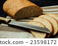 Sliced bread and knife on linen cloth, black table 23598172