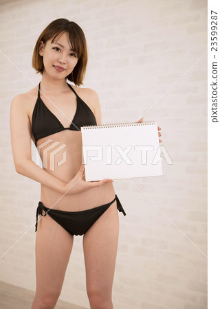 在手中穿有白板的一個女性模型黑比基尼泳裝 23599287