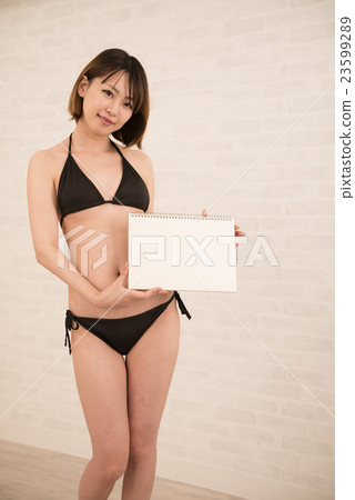 在手中穿有白板的一個女性模型黑比基尼泳裝 23599289