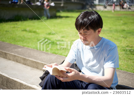 A man sitting at the step and reading A man sitting at the step and reading 23603512