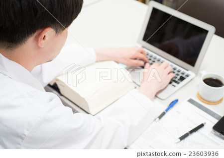 Male in white coat making desk work 23603936