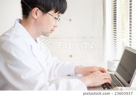 在做書桌工作的白色外套的男性 在做書桌工作的白色外套的男性 23603937