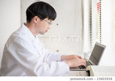 Male in white coat making desk work 23603938