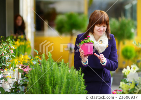 Beautiful woman selecting flowers at flower market Beautiful woman selecting flowers at flower market 23606937