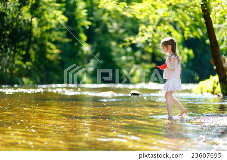 Adorable little girl playing with paper boats 23607695