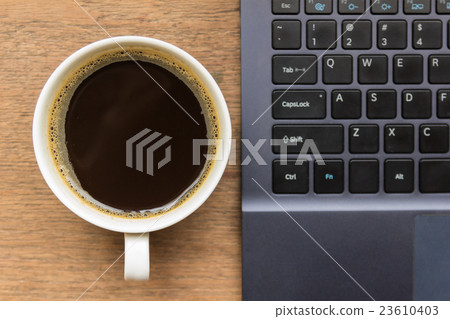 Top view of coffee cup , laptop on wooden table Top view of coffee cup , laptop on wooden table 23610403