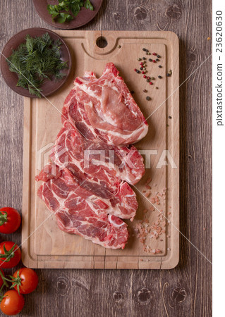 Fresh raw pork chop meat on cutting board 23620630