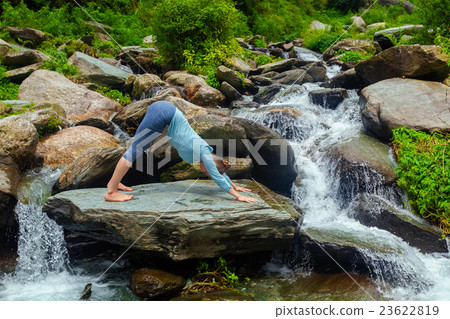 Young sporty fit woman doing yoga oudoors at 23622819