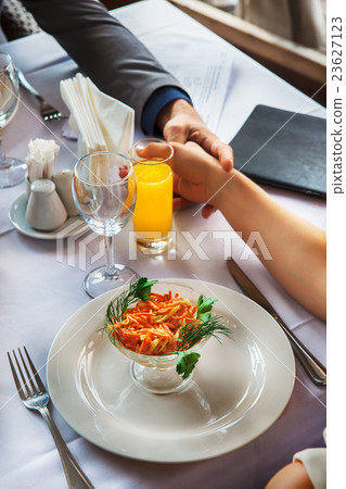 Hands of romantic couple over a restaurant table 23627123