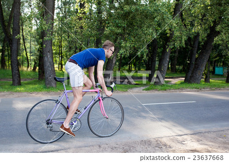 man riding a bike on the road 23637668
