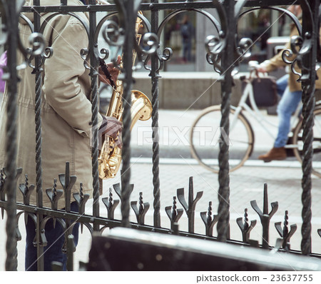 african street musician playing jazz on saxophone 23637755