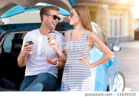 Man and woman drinking coffee on trunk Man and woman drinking coffee on trunk 23639320