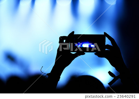 Capturing a video on a mobile phone at concert 23640291