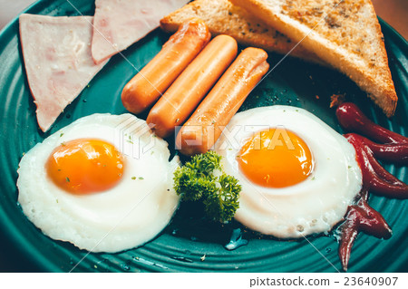 Breakfast with fried eggs, bacon and sausages. Breakfast with fried eggs, bacon and sausages. 23640907