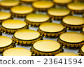 many yellow bottle caps on white background 23641594