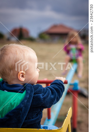 Boy and girl on a swing 23642780