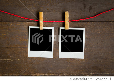 two blank photo frame hanging on wood background 23643521
