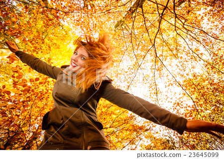 Unusual angle of young woman in autumn park 23645099