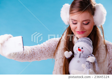 Woman with little snowman taking selfie photo. Woman with little snowman taking selfie photo. 23645124