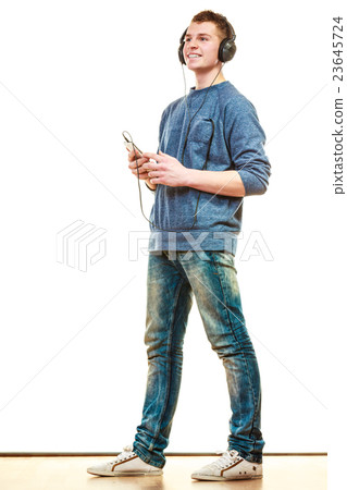 Young man with headphones listening music Young man with headphones listening music 23645724