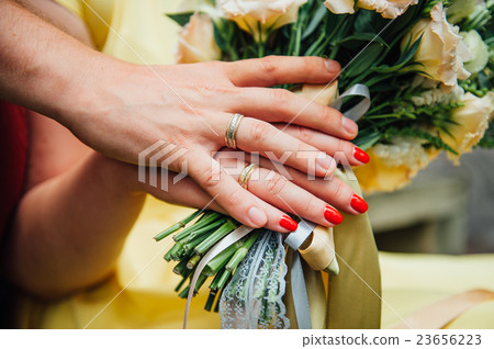 Hands and rings on wedding bouquet close up Hands and rings on wedding bouquet close up 23656223