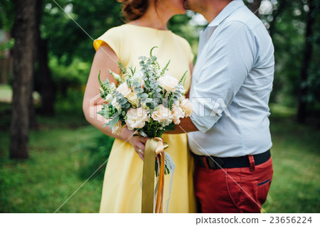Beautiful wedding bouquet in hands of the bride Beautiful wedding bouquet in hands of the bride 23656224