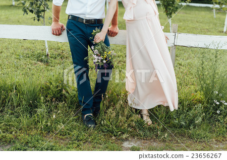 Pregnant woman holding wildflowers at the park 23656267