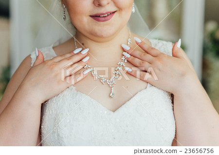 the fat bride wears a necklace around his neck 23656756