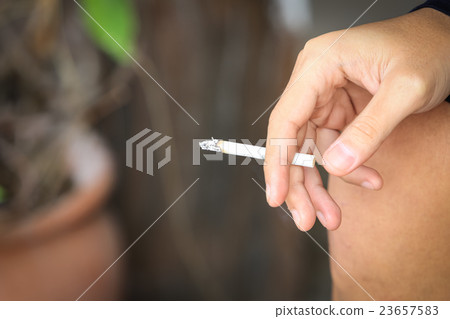 Close up hand holding cigarette. stop smoking, selective focus 23657583
