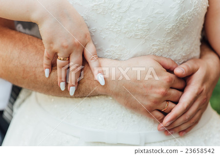 Hands and rings on a body of fat bride 23658542