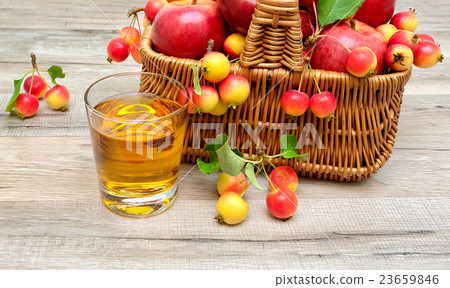 glass of apple juice and ripe apples in a basket 23659846