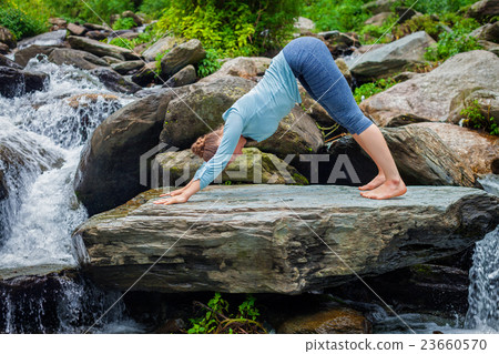 Young sporty fit woman doing yoga oudoors at 23660570