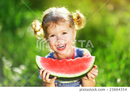 Happy child girl eats watermelon 23664354