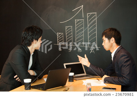 Bar graph: Two no-tie businessmen meeting in front of the blackboard 23670981