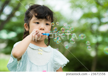 Girls playing with soap bubbles Girls playing with soap bubbles 23671556