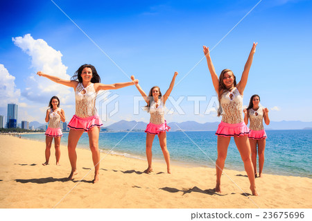cheerleaders dance differently beach against sea 23675696