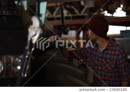 Men maintaining tractors 23680280