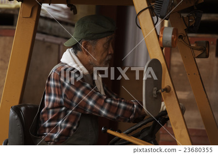 一名男子駕駛一輛拖拉機 23680355