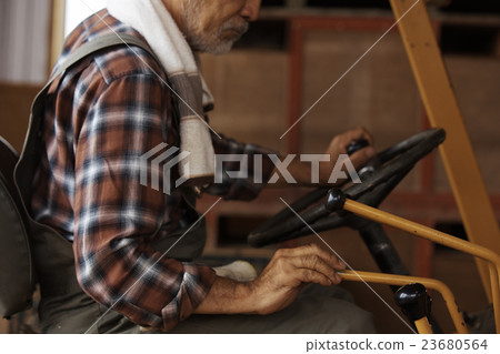 A man driving a tractor 23680564