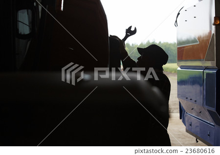 Farmer maintaining tractor 23680616