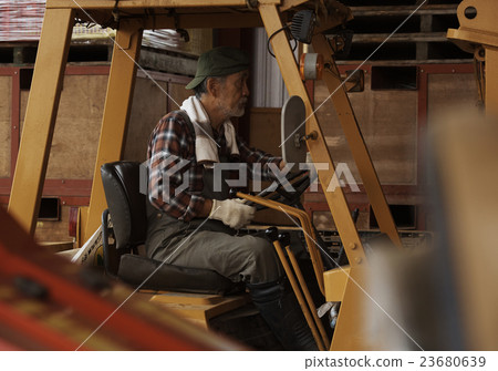 一名男子駕駛一輛拖拉機 一名男子駕駛一輛拖拉機 23680639