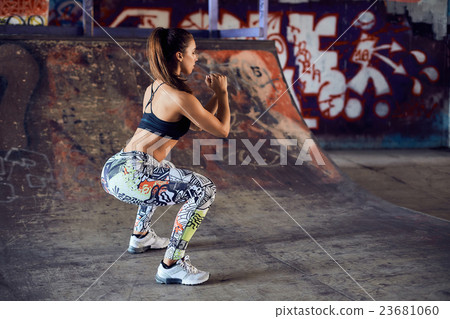 Squatting muscular woman on the urban city Squatting muscular woman on the urban city 23681060